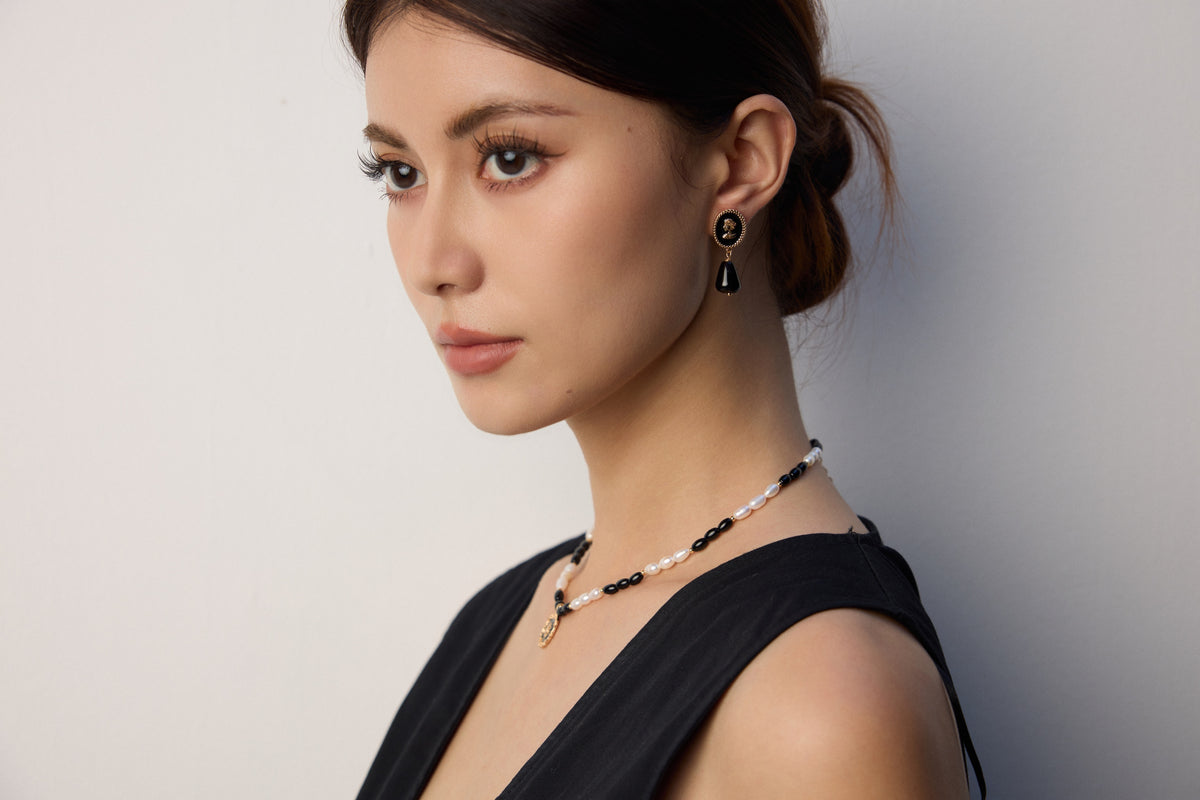 Kairos model wearing symbolic pearl and gold jewelry